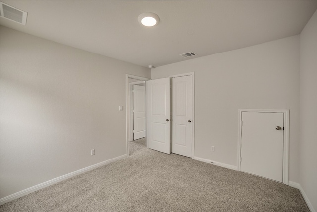 unfurnished bedroom featuring light carpet and a closet