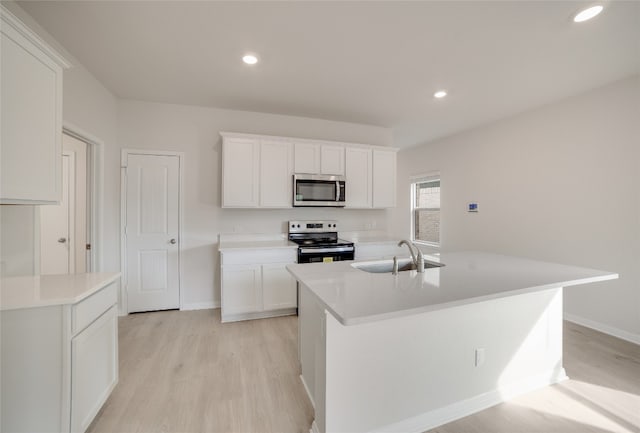 kitchen featuring a kitchen island with sink, sink, white cabinets, and appliances with stainless steel finishes