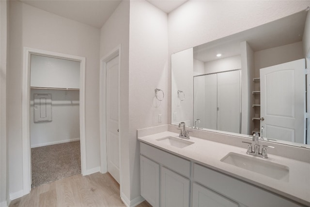 bathroom with hardwood / wood-style floors, vanity, and walk in shower