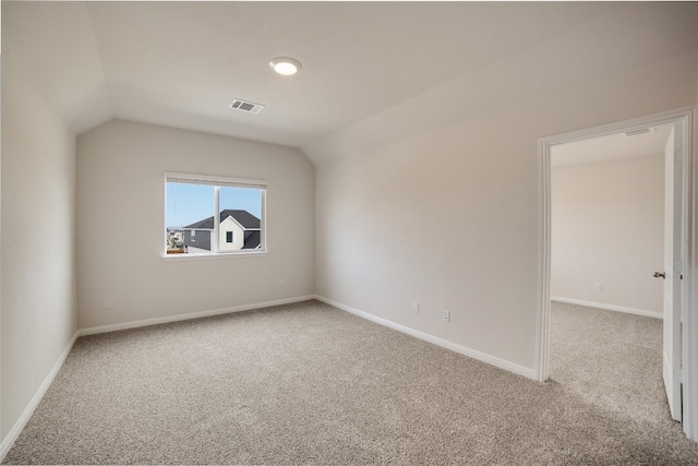 additional living space featuring light carpet and vaulted ceiling