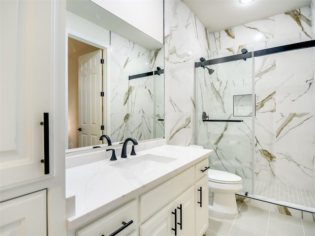 bathroom with vanity, tile patterned flooring, toilet, and a shower with door