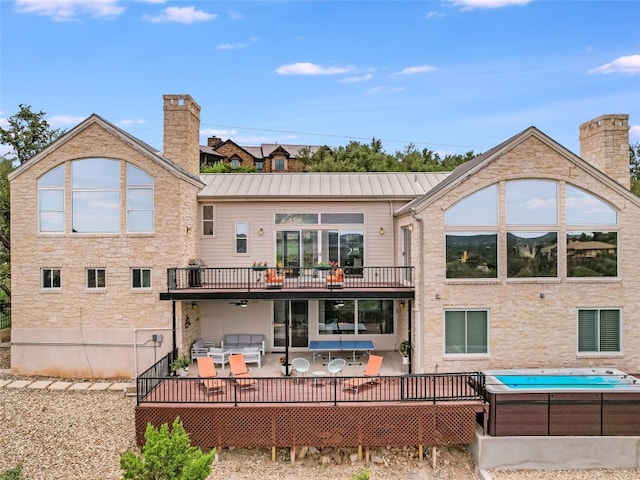 back of house with a balcony, an outdoor living space, and a wooden deck