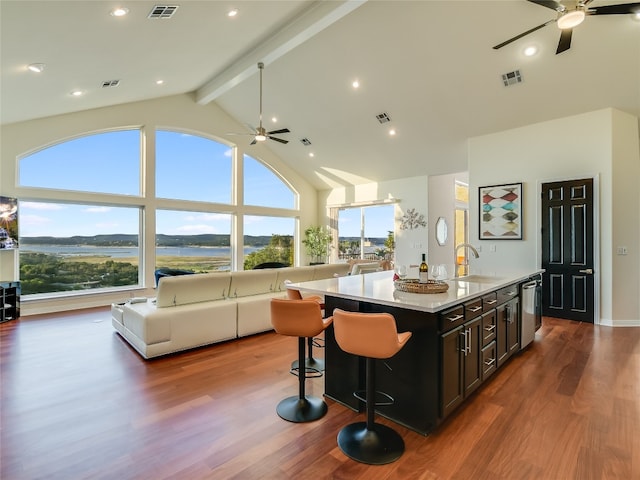 kitchen featuring wood-type flooring, sink, a center island with sink, ceiling fan, and stainless steel dishwasher