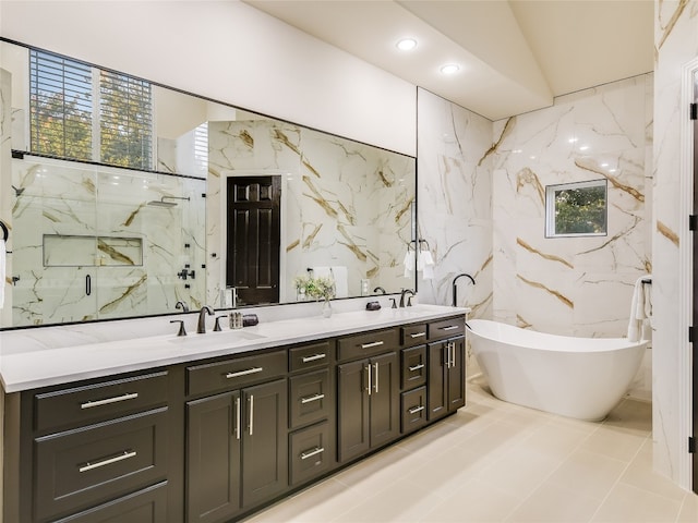 bathroom with tile walls, independent shower and bath, and vanity