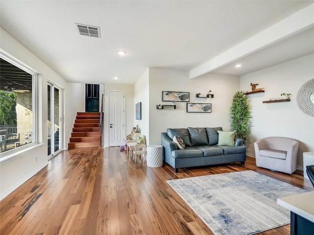 living room featuring wood-type flooring and beam ceiling