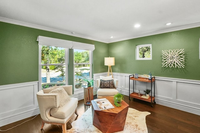 living area featuring plenty of natural light, crown molding, and a wainscoted wall