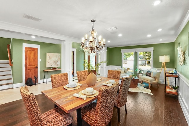 dining area with hardwood / wood-style flooring, visible vents, and wainscoting