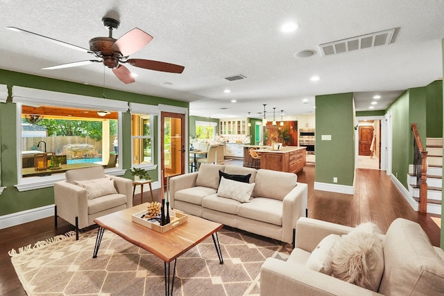 living area featuring recessed lighting, visible vents, dark wood-type flooring, and ceiling fan