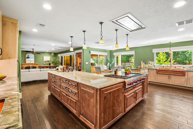 kitchen with visible vents, a spacious island, dark wood-style floors, open floor plan, and stainless steel gas cooktop