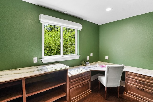 office space with built in desk and a textured wall