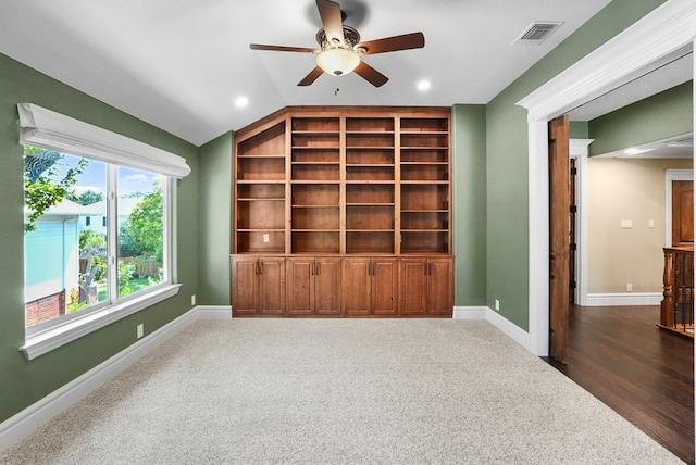 interior space featuring visible vents, built in shelves, baseboards, ceiling fan, and lofted ceiling