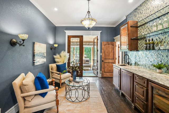 kitchen featuring light stone counters, dark wood finished floors, open shelves, a sink, and crown molding