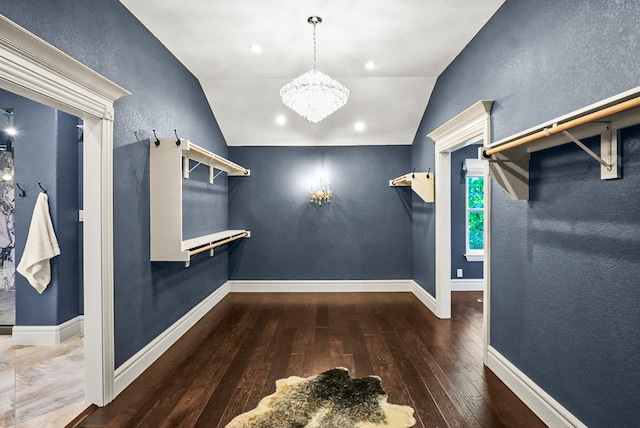 walk in closet with lofted ceiling, a chandelier, and hardwood / wood-style flooring