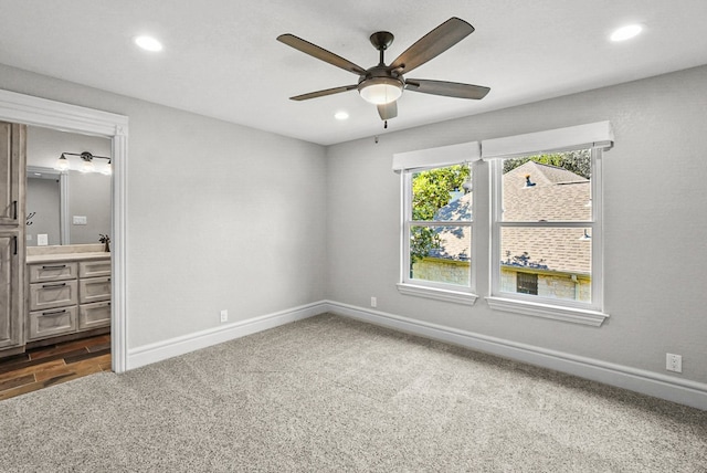 unfurnished bedroom featuring connected bathroom, baseboards, ceiling fan, dark carpet, and recessed lighting