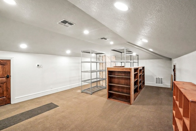 interior space with visible vents, a textured ceiling, and carpet floors