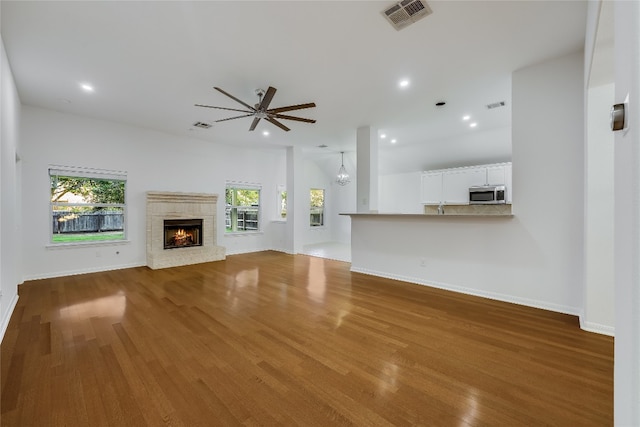 unfurnished living room with a healthy amount of sunlight, ceiling fan, and hardwood / wood-style flooring