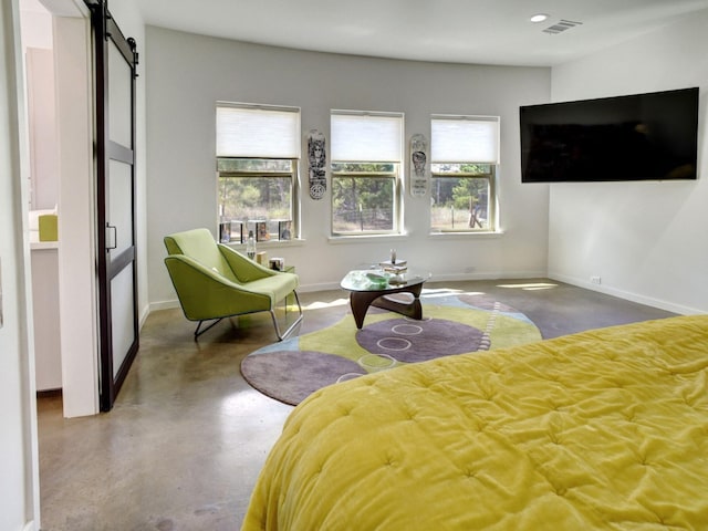 bedroom featuring a barn door and concrete floors