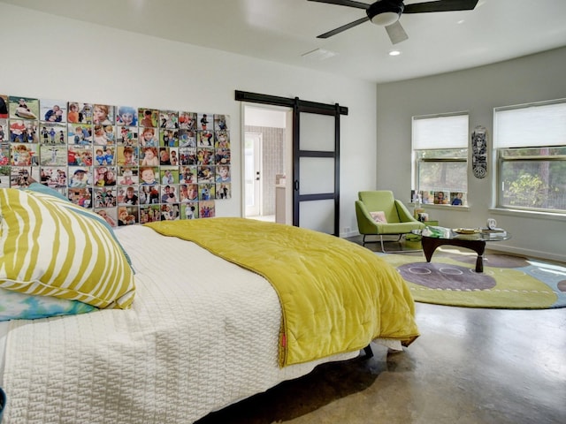 bedroom with a barn door, ceiling fan, and concrete flooring