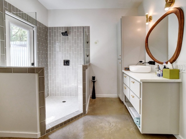 bathroom with a tile shower and vanity