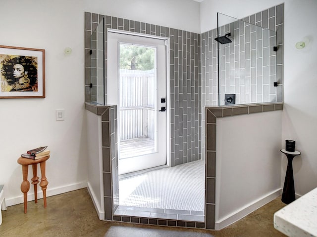 bathroom with concrete flooring and a tile shower