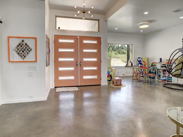 foyer with an inviting chandelier and french doors