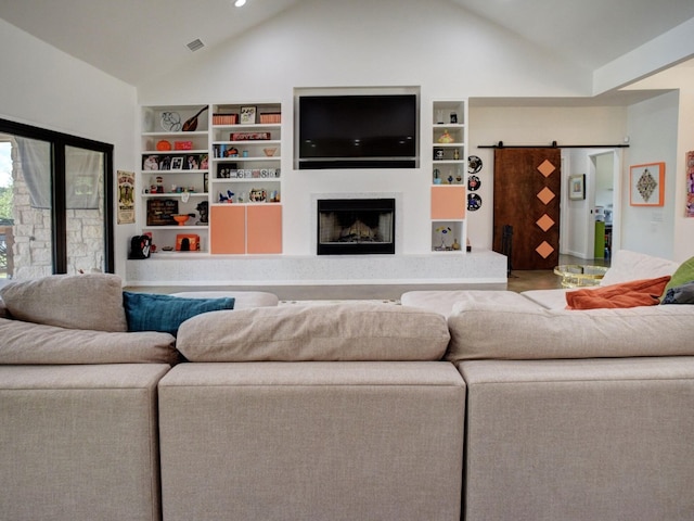 living room featuring lofted ceiling and a barn door