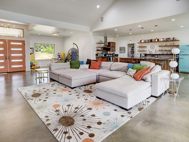 living room with high vaulted ceiling, concrete flooring, french doors, and sink