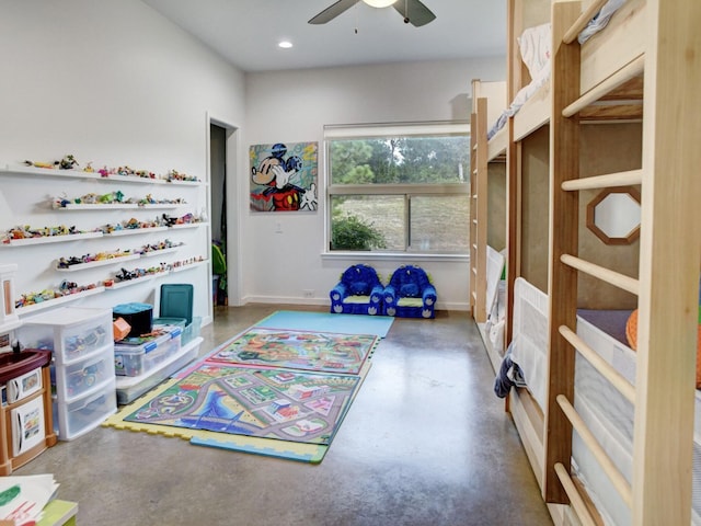 playroom featuring ceiling fan and concrete flooring