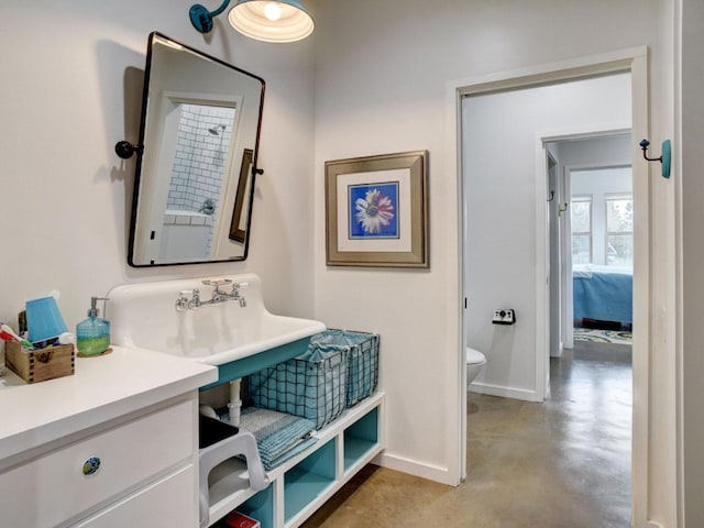 bathroom featuring concrete flooring, vanity, and toilet