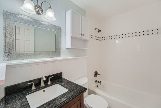 full bathroom featuring tiled shower / bath combo, vanity, and toilet