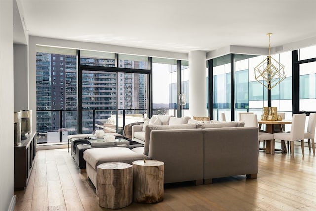 living room with expansive windows, light hardwood / wood-style flooring, and an inviting chandelier