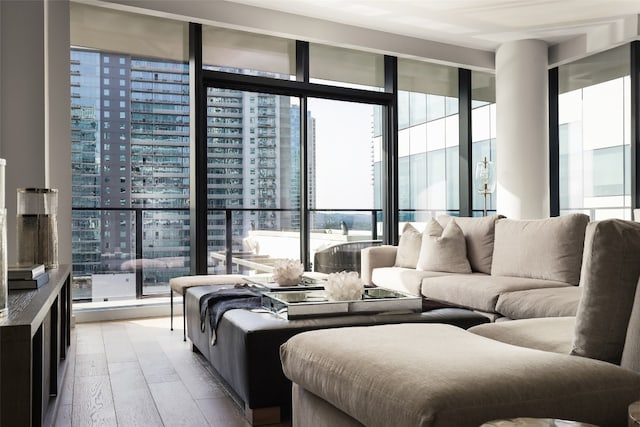 living room with light wood-type flooring and a wall of windows