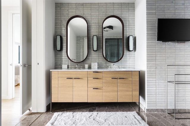 bathroom with vanity and tile walls