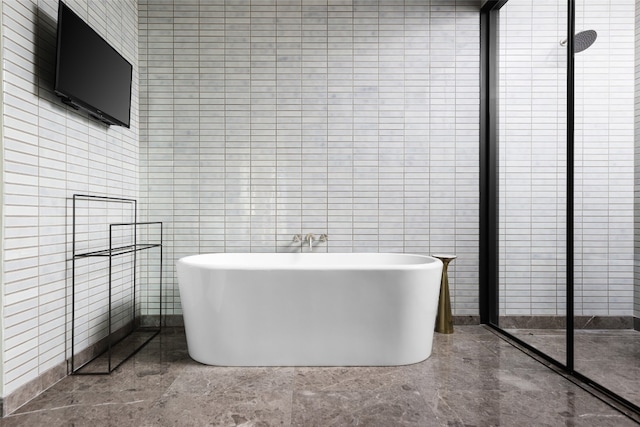 bathroom featuring tile walls and shower with separate bathtub