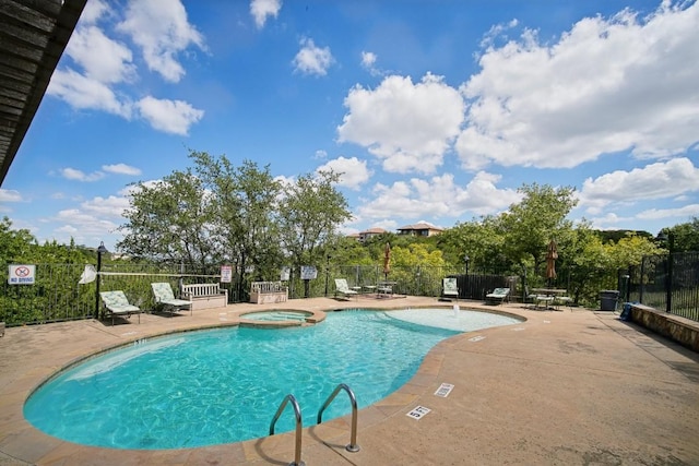 view of swimming pool featuring a community hot tub and a patio area