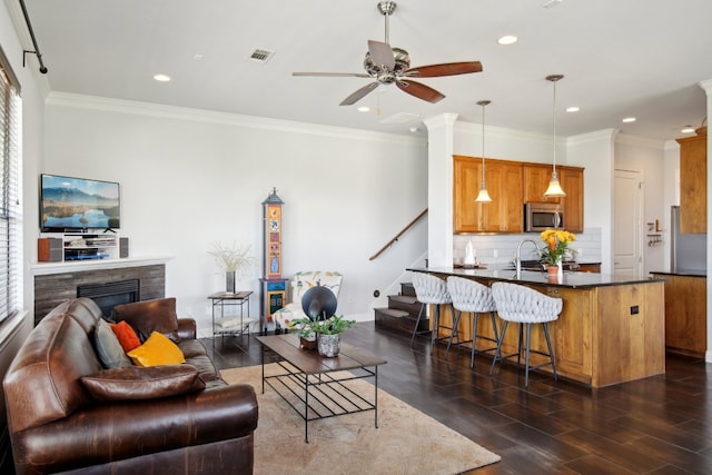 living room with ceiling fan, ornamental molding, dark hardwood / wood-style flooring, and sink