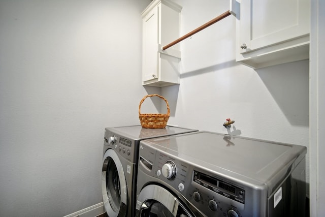 washroom with washer and clothes dryer and cabinets