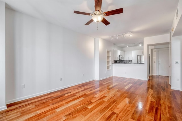 unfurnished living room featuring light wood-type flooring, ceiling fan, and built in features