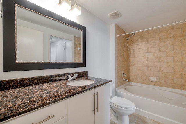 full bathroom with tile patterned floors, tiled shower / bath, vanity, and toilet