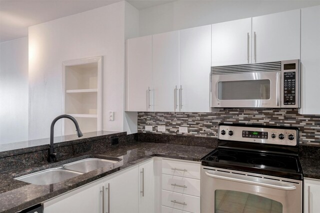 54 Rainey St Unit 1015, Austin, TX 78701 - kitchen featuring stainless steel appliances, a sink, white cabinets, backsplash, and dark stone countertops