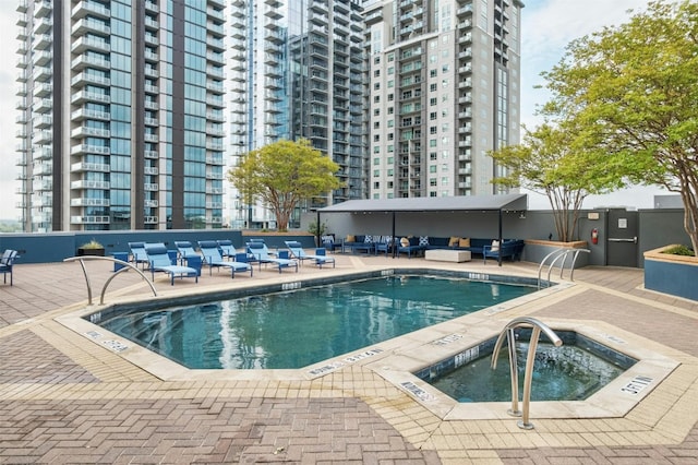 view of swimming pool featuring a community hot tub and a patio