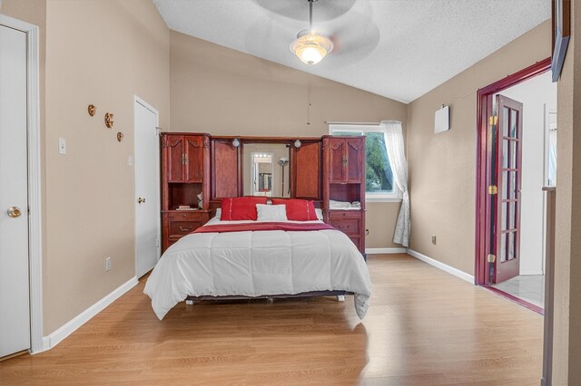 bedroom featuring ceiling fan, a textured ceiling, lofted ceiling, and light hardwood / wood-style flooring