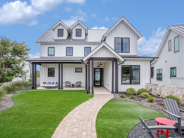 modern farmhouse featuring covered porch and a front yard