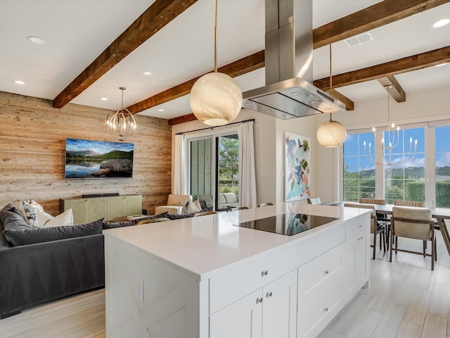 kitchen with hanging light fixtures, a kitchen island, island range hood, black electric stovetop, and a wealth of natural light