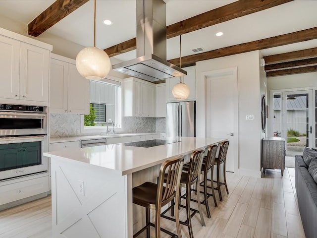 19601 Flying J Blvd Unit 15, Spicewood, TX 78669 - kitchen with stainless steel appliances, beam ceiling, tasteful backsplash, island range hood, and white cabinetry