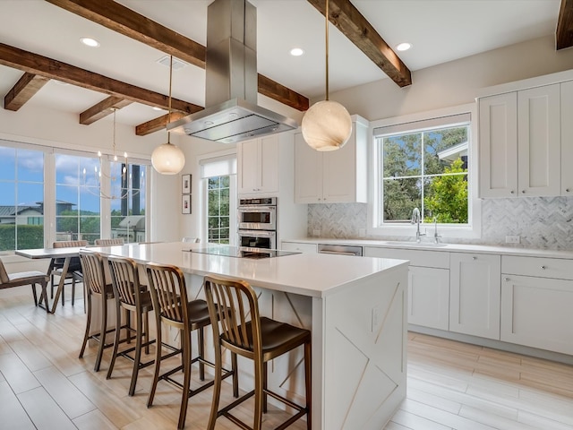 kitchen featuring island exhaust hood, a kitchen island, and decorative light fixtures