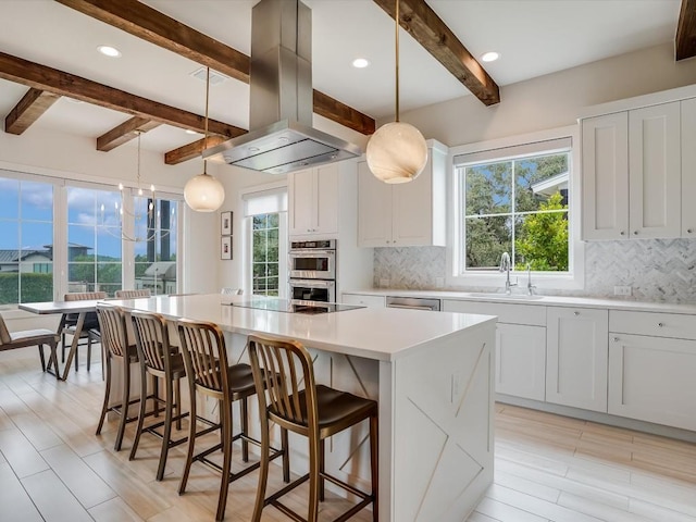 19601 Flying J Blvd Unit 15, Spicewood, TX 78669 - kitchen featuring island exhaust hood, beamed ceiling, a kitchen island, decorative backsplash, and healthy amount of natural light