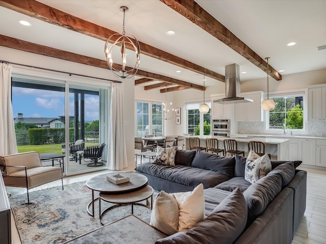 living room featuring a notable chandelier, light wood-type flooring, and plenty of natural light