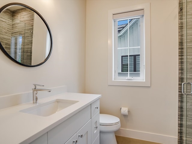 bathroom featuring a healthy amount of sunlight, a shower with door, vanity, and toilet