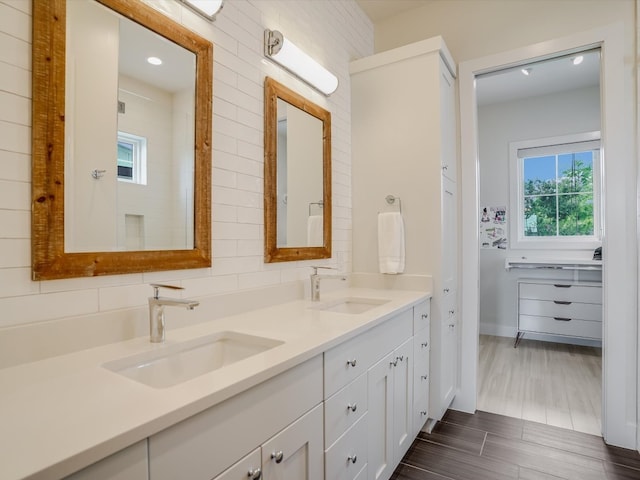 bathroom with vanity, hardwood / wood-style floors, and tasteful backsplash